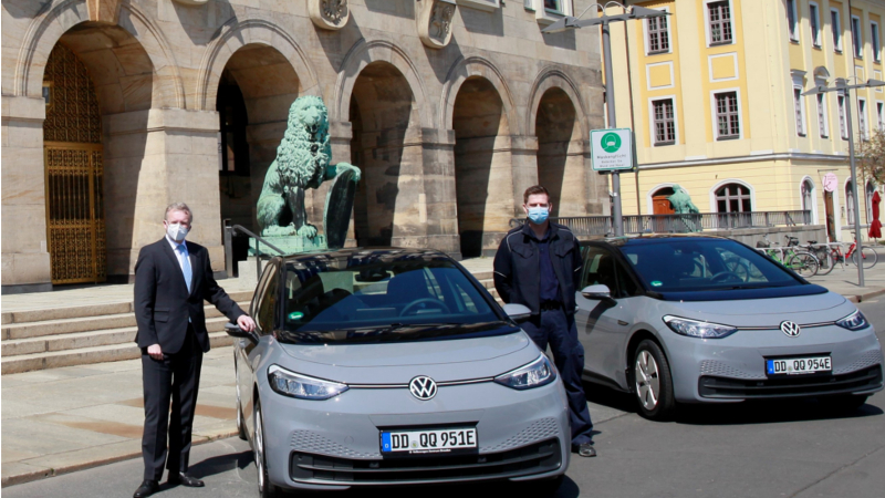 Ordnungsbürgermeister Detlef Sittel (links) und Silvio Franz vom Gemeindlichen Vollzugsdienst neben einem der neuen VW ID. 3 Foto: Landeshauptstadt Dresden