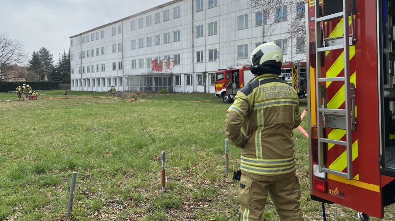© Feuerwehr Dresden Leichte Rauchentwicklung an Bürogebäude, Feuerwehrmann im Vordergrund