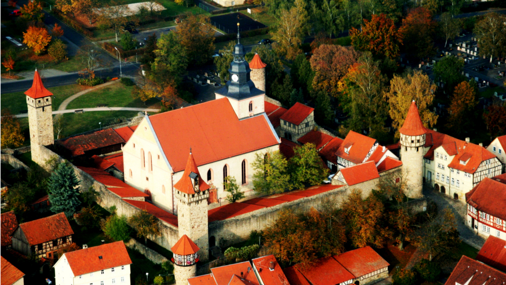 Blick von oben auf die beeindruckende Kirchenburg in Ostheim vor der Rhön. Im Zentrum steht die majestätische Kirche St. Michael. Foto: DJD/Verein für Stadtmarketing Ostheim