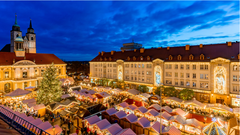 Stimmungsvolles Bild vom Magdeburger Weihnachtsmarkt mit den vielen Buden auf dem Alten Markt vor dem historischen Rathaus. Foto: DJD/Magdeburg Marketing/Andreas Lander