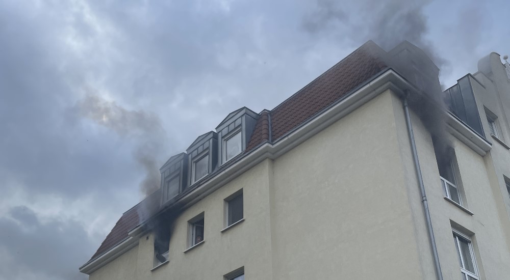 © Feuerwehr Dresden +-  Dichter, schwarzer Brandrauch dringt aus der dritten Etage des Mehrfamiliengebäudes.