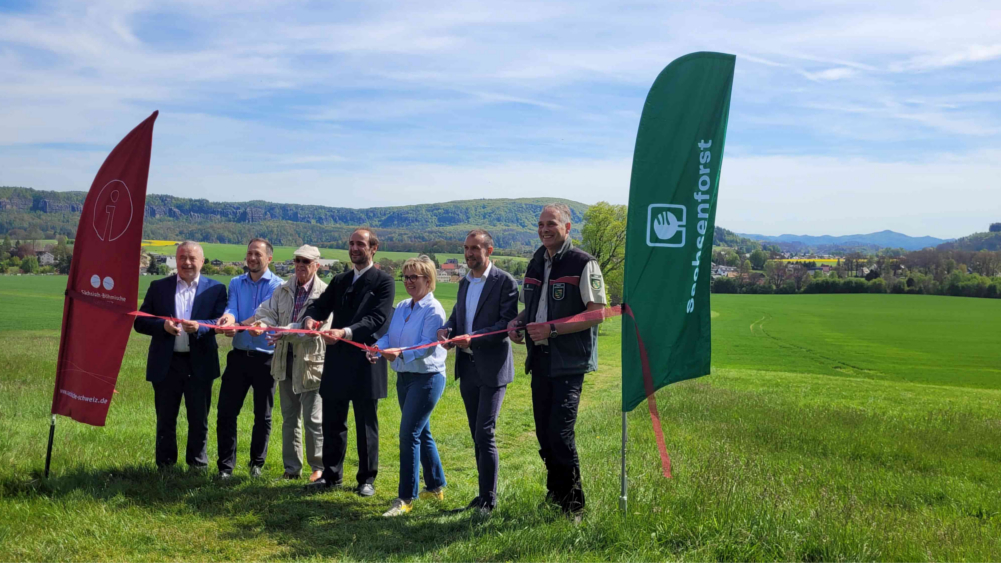 Viele Partner haben bei dem Projekt mitgewirkt und durften alle zurecht am Fuße des Wolfsberges das Band durchschneiden v.l.): Landrat Michael Geisler als Vorsitzender des Tourismusverbandes, Thomas Kunack, Bürgermeister Bad Schandau, Gerhard Englick brachte viel Hintergrundwissen zu C.-D.-F ein, Schauspieler Johannes Gärtner gab den Friedrich und machte seine Persönlichkeit in der freien Landschaft wieder lebendig, Staatsministerin Barbara Klepsch vertrat die Staatsregierung, Dr. Andreas Heine ist der gastgebende Bürgermeister von Reinhardsdorf-Schöna und Uwe Borrmeister, Leiter der Nationalpark- und Forstverwaltung. © Hp. Mayr