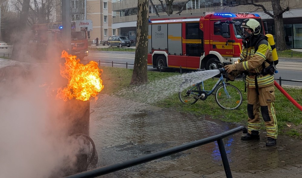 © Feuerwehr Dresden  - Mit Wasser aus einem Strahlrohr wird der brennende Bitumofen gekühlt.