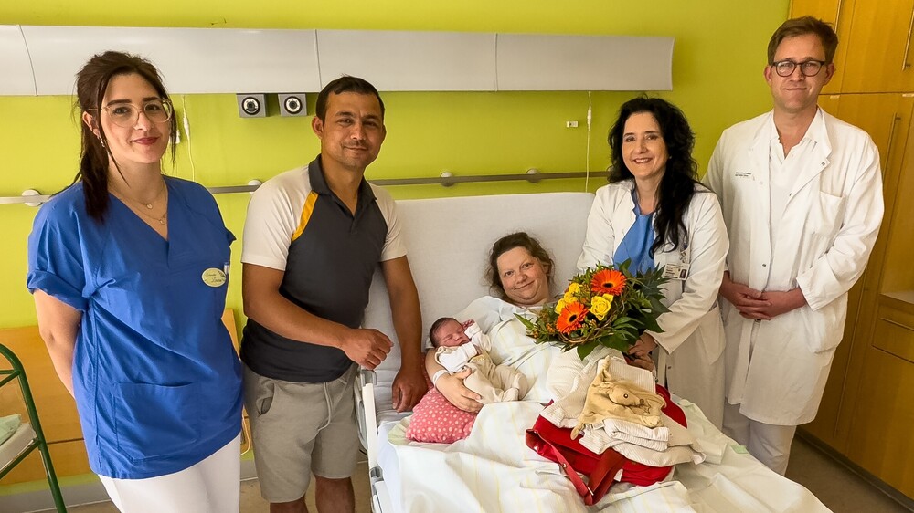Bildtext: Prof. Pauline Wimberger (2.v.r.), Direktorin der Klinik für Frauenheilkunde und Geburtshilfe am Uniklinikum Dresden, überbringt Glückwunsche an Ina und Gürcan, die sich über Sohnemann Yunus Paul freuen. Er ist das 1.000. Baby, das in diesem Jahr hier geboren wurde. Foto: UKD/Marc Eisele