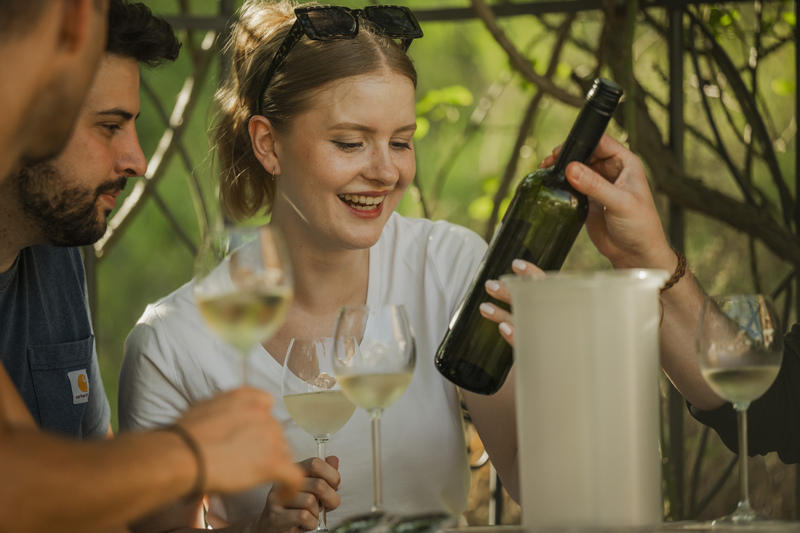 Den Wein mit allen Sinnen erleben: Eine Weinflasche wird aufmerksam betrachtet – ein Moment der Neugier und Vorfreude auf den Genuss. Foto: Martin Förster (