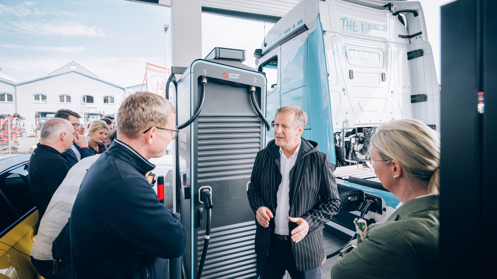 Carsten Wald (Mitte), Leiter der Elektromobilität bei SachsenEnergie, erklärt die Funktionen im Ladepark Pirna.  Foto: SachsenEnergie