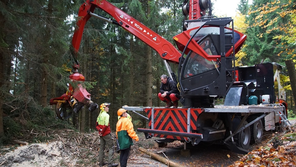 Annette Schmidt-Scharfe, Revierleitern des Forstreviers Unger der Nationalpark- und Forstverwaltung von Sachsenforst, bespricht den Seilkran-Einsatz mit dem Maschinenführer. Für die beiden erfahrenen Forstwirte Lucas Hänsel und Gerrit Hamel ist es eine gute Gelegenheit, diese besondere Technik im Einsatz am Steilhang zu begutachten. Foto:  K. Partzsch