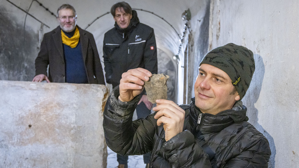 Markus Bitterlich hält ein Fundstück in der Hand: eine Keramikscherbe eines Kochgeschirrs, vermutlich 18. Jahrhundert oder älter. Foto: Marko Förster/Festung Königstein gGmbH.
