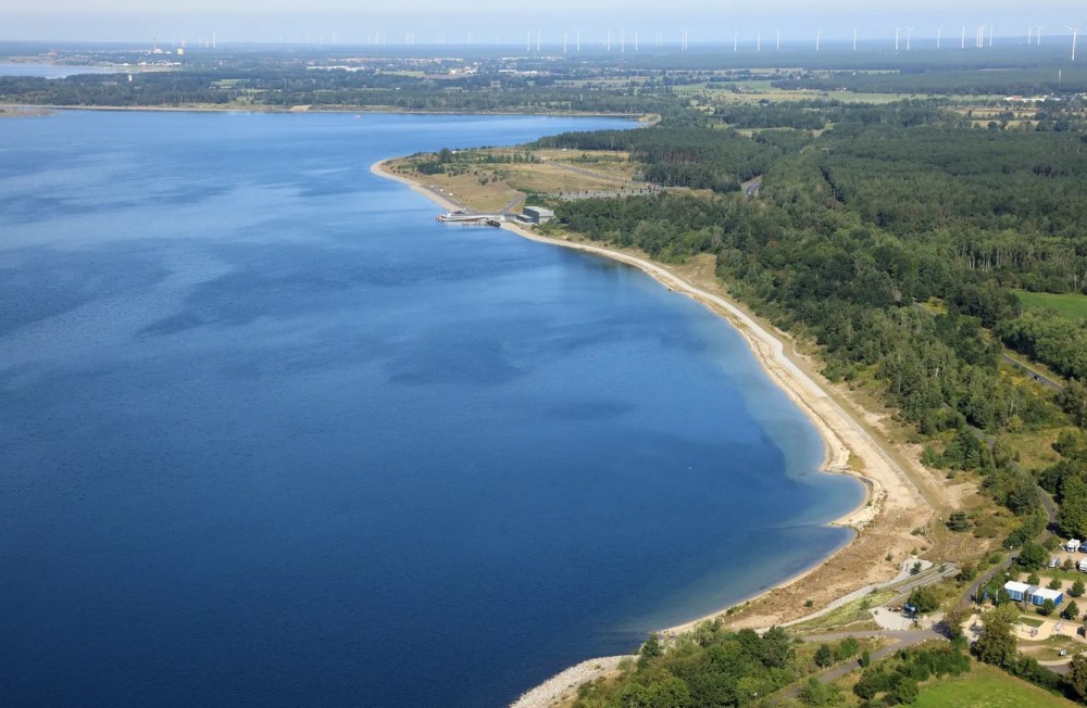 Nordostböschung des Sedlitzer Sees mit Seestrand Lieske und Sanierungsstützpunkt im Hintergrund  Foto: LMBV