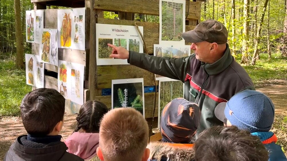 Forstinspektoranwärter Jonas Andruschek mit Schülerinnen und Schülern an einer Station mit Tastboxen © Jana Mothes, Sachsenforst