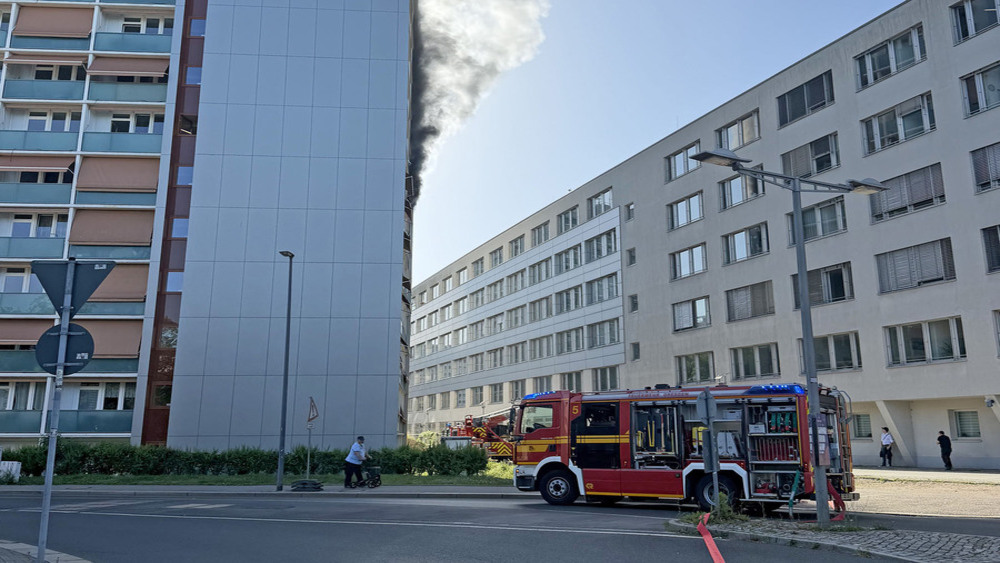 © Roland Halkasch Rauchentwicklung an Wohnhochhaus, im Vordergrund steht ein Löschfahrzeug